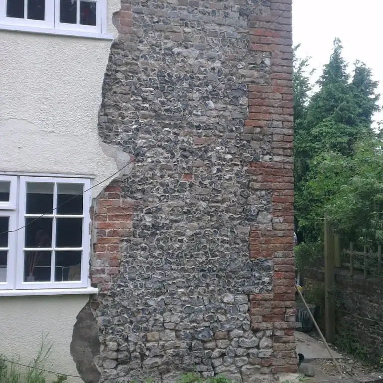 Flint and brick wall uncovered after failed cement render was removed
