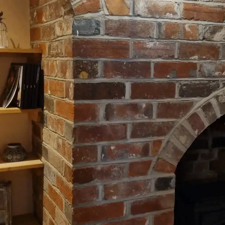 Fireplace opening with reclaimed timber beam and lime-hemp plaster finish