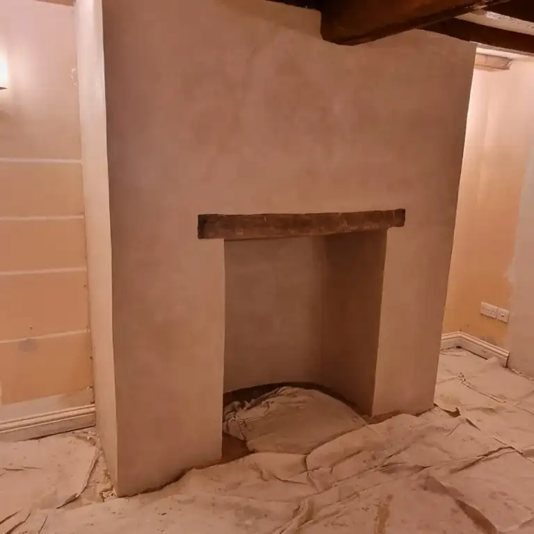 Fireplace opening with reclaimed timber beam and lime-hemp plaster finish