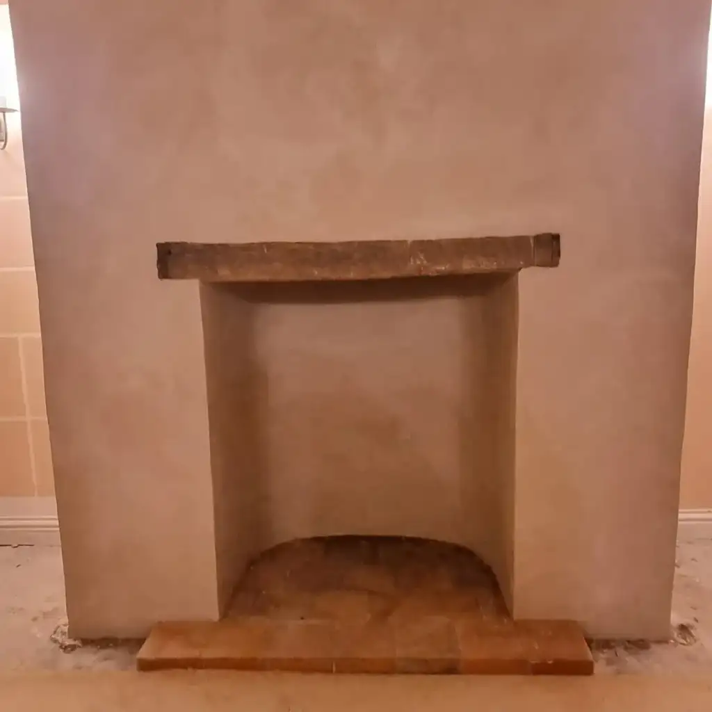 Fireplace opening with reclaimed timber beam and lime-hemp plaster finish