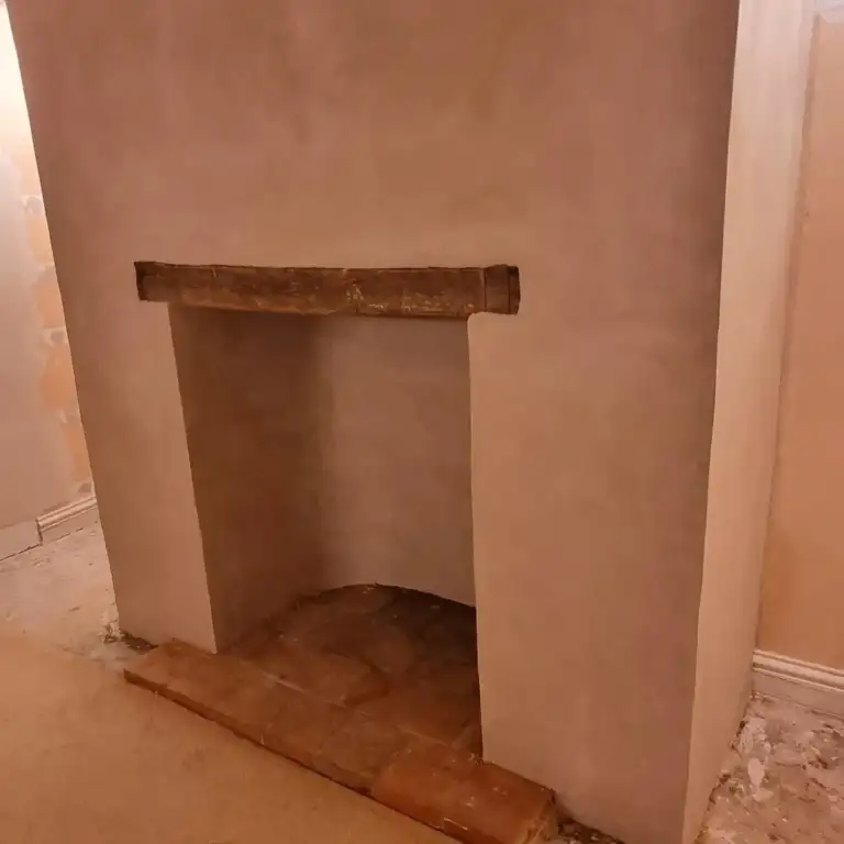 Fireplace opening with reclaimed timber beam and lime-hemp plaster finish