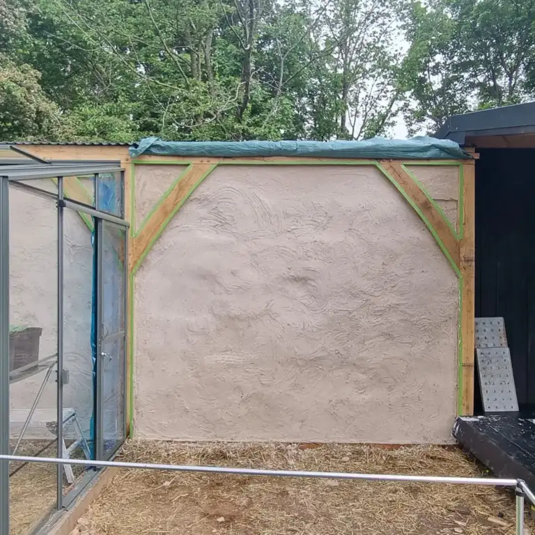 Lime render being applied by hand to a new straw-bale wall