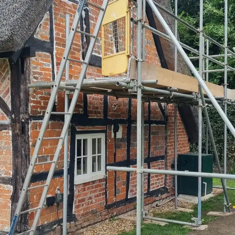 Timber-framed house with brick infill panels removed ready for new timbers