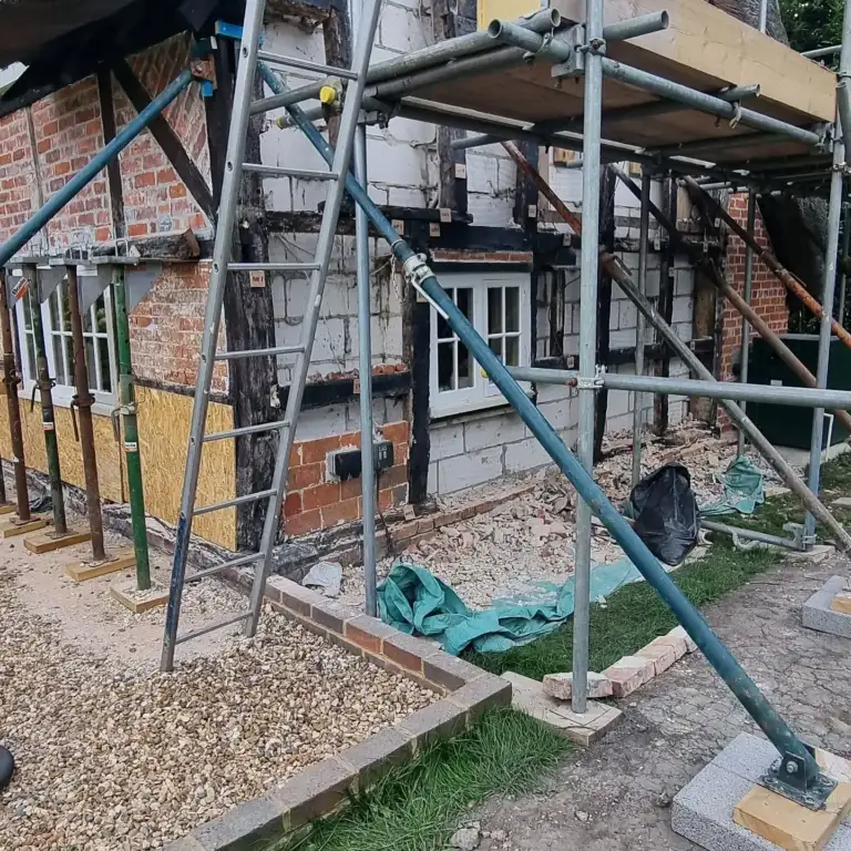 Timber-framed house with brick infill panels removed ready for new timbers